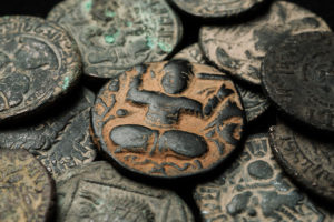 Ancient,Islamic,Copper,Coin,In,Pile,Of,Other,Coins,,Close-up